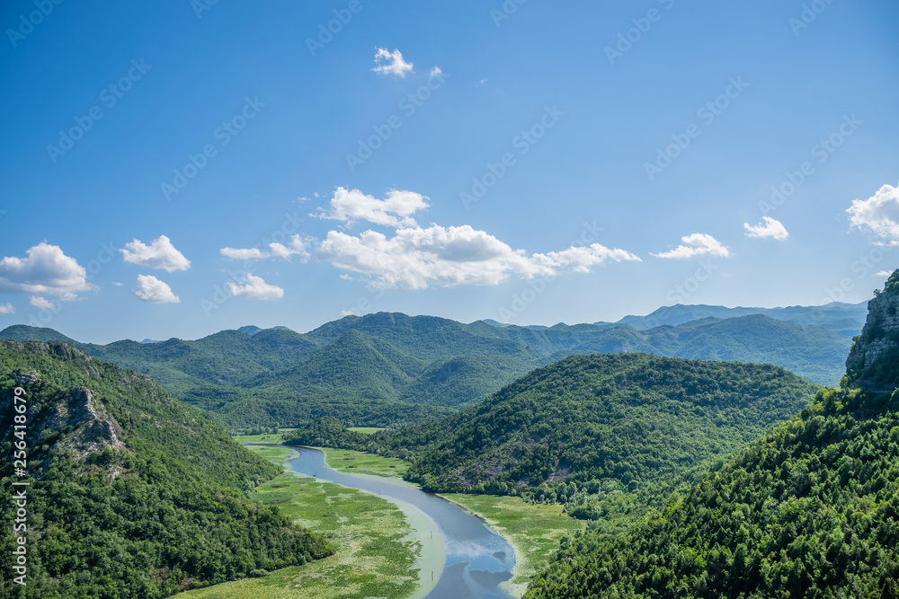 Fototapeta premium The picturesque meandering river flows among green mountains.