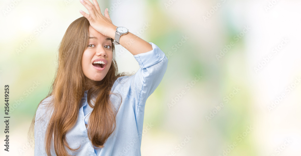 Young beautiful brunette business woman over isolated background surprised with hand on head for mistake, remember error. Forgot, bad memory concept.