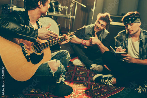 Quadro su tela selective focus of musician holding acoustic guitar near cheerful friends