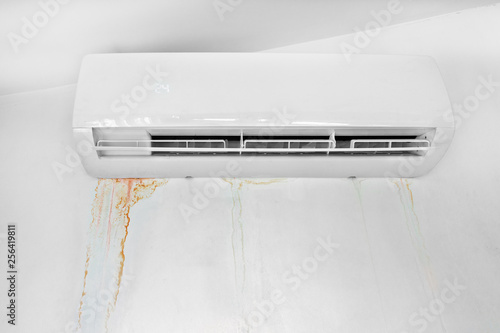 Wall with mold stain due to air conditioner leakage. Mildew stains and destruction of the wall. Improper installation of device.