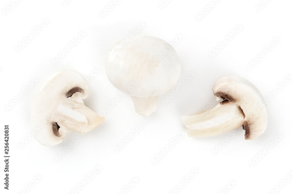 Fototapeta premium Three champignon mushrooms, shot from above on a white background, a flat lay composition with a place for text