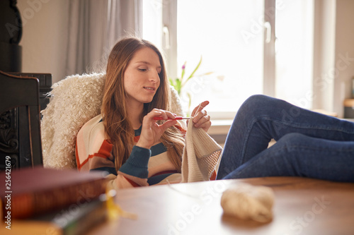 Young woman crochets at a table photo