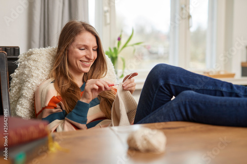 Young woman crochets at a table
