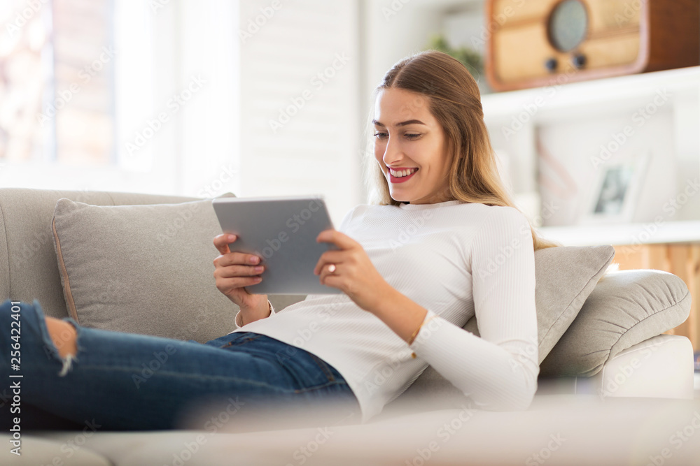 Young woman using digital tablet at home Young woman using digital tablet at home