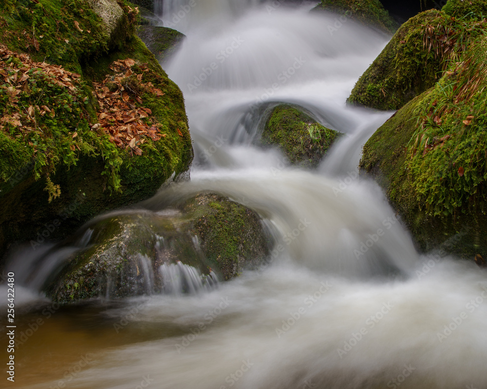 Wasserfall mit Steinen voller Moos Wasserfall mit Steinen voller Moos