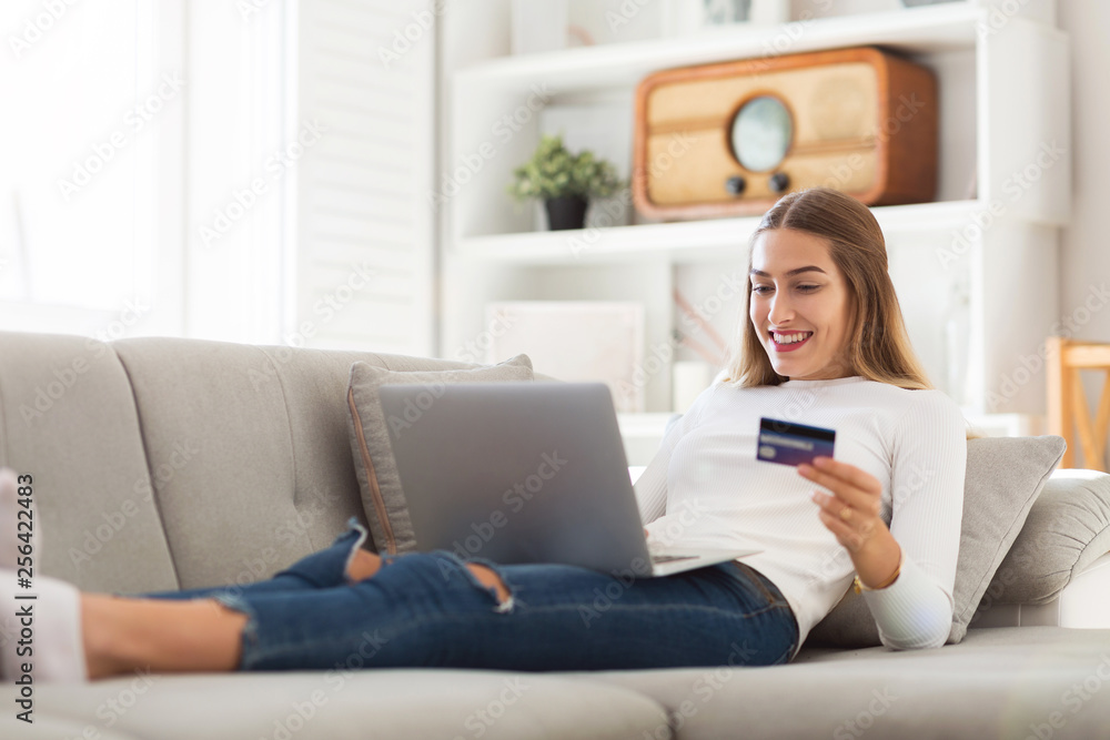 Woman on couch with credit card and laptop Woman on couch with credit card and laptop