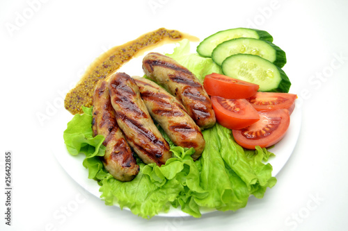 fried sausages and salad on a white plate