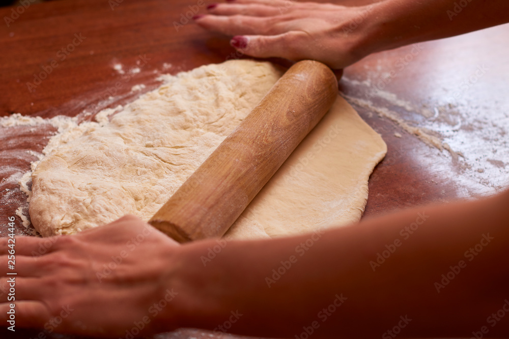 Dough for pizza. Rolling pin and dough on wooden background Dough for pizza. Rolling pin and dough on wooden background