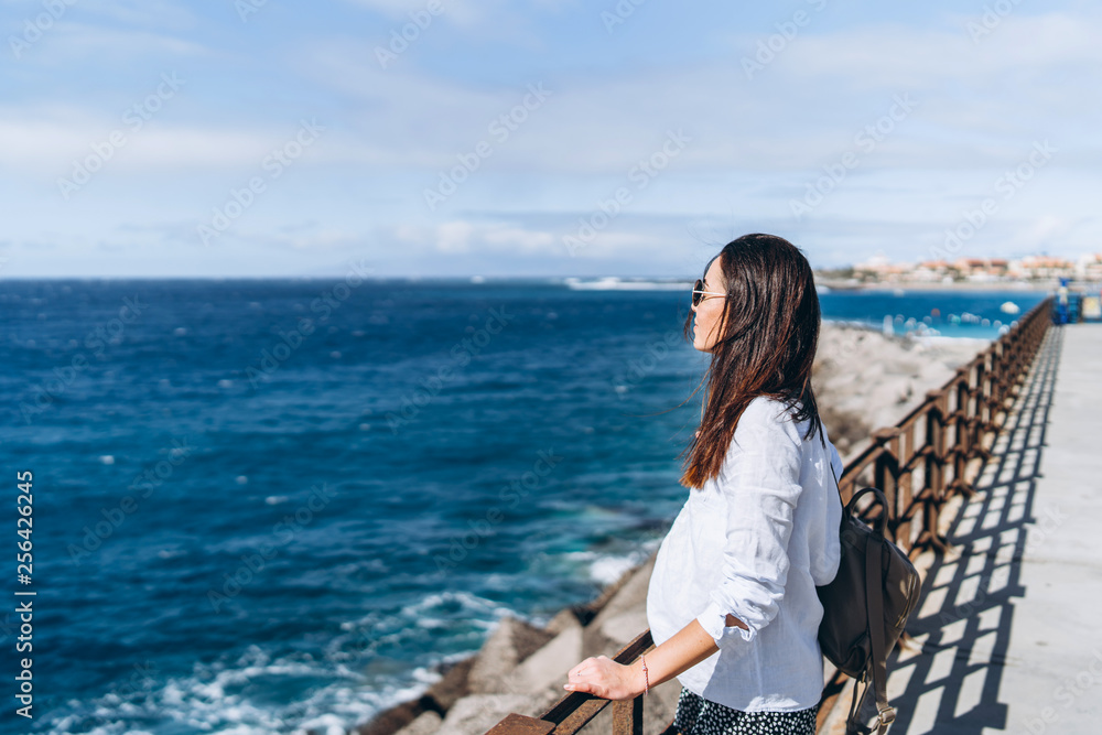 Pretty long hair brunette girl relaxing near ocean. Pretty long hair brunette girl relaxing near ocean.