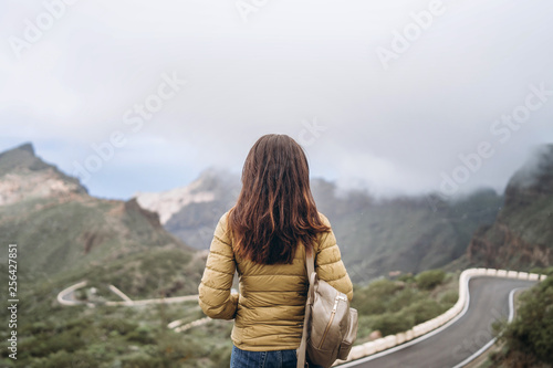 Pretty tourist brunette girl relaxing near mountains.