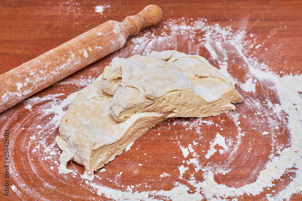 Dough for pizza on the wooden table, close-up. Dough for pizza. Dough for pizza on the wooden table, close-up. Dough for pizza.