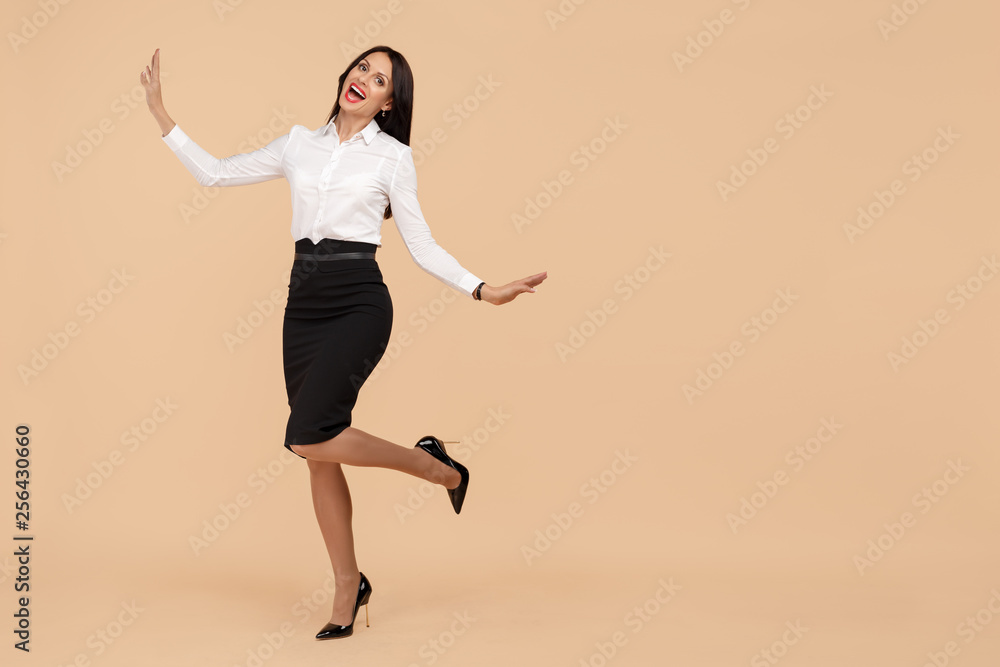 Happy young modern business woman over beige background. Success and winner concept. Happy young modern business woman over beige background. Success and winner concept.