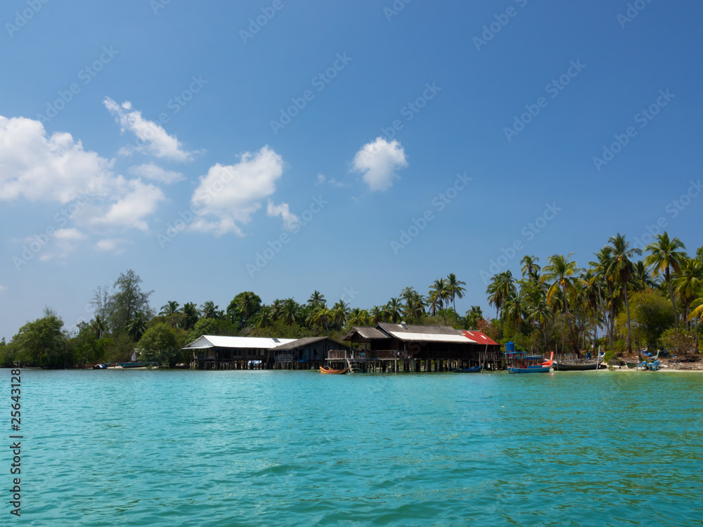 Fishermen village on tropical island..Landscape of house on the seashore with pier at andaman sea  in a sunny day cloud blue sky.