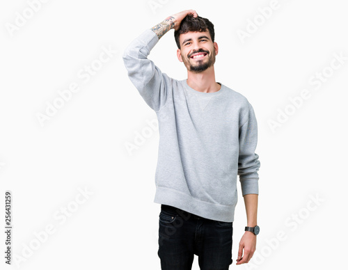 Young handsome man wearing sweatshirt over isolated background Smiling confident touching hair with hand up gesture, posing attractive