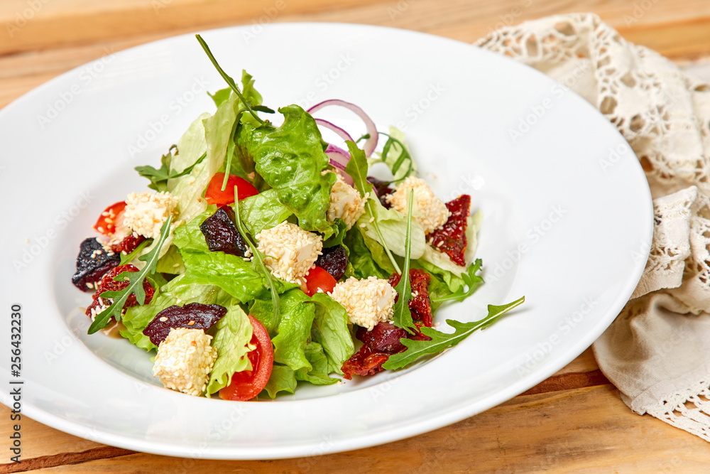 vegetarian salad with dried tomatoes and croutons on the wooden background vegetarian salad with dried tomatoes and croutons on the wooden background