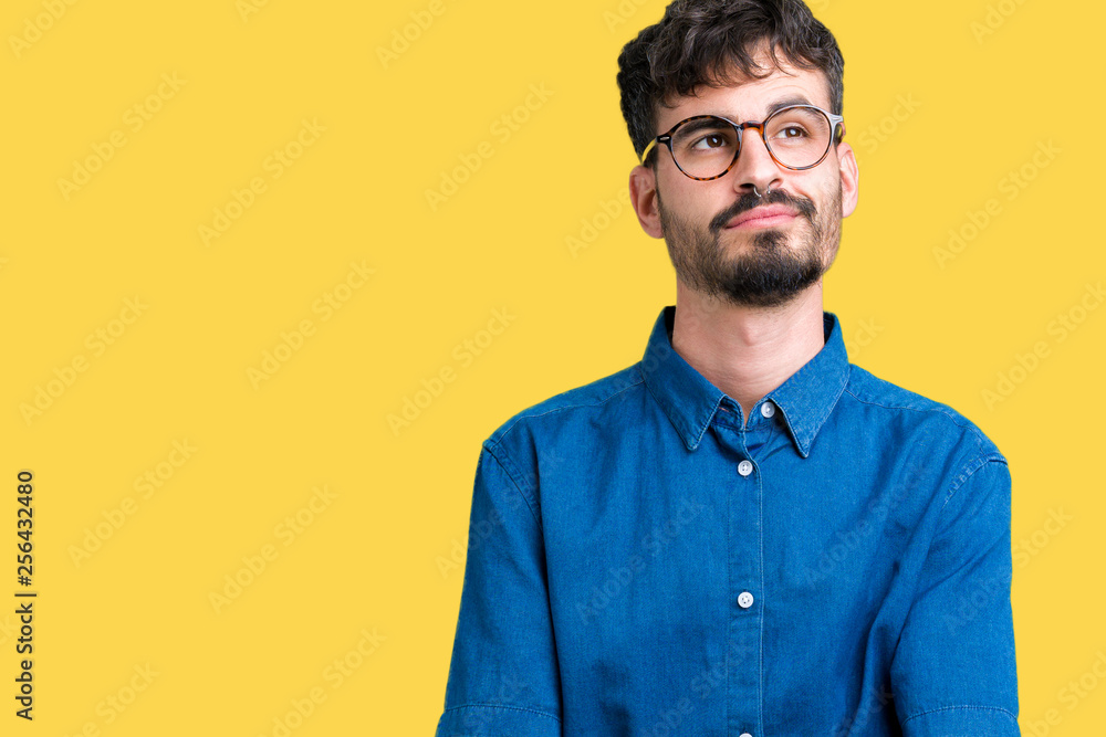 Obraz premium Young handsome man wearing glasses over isolated background smiling looking side and staring away thinking.