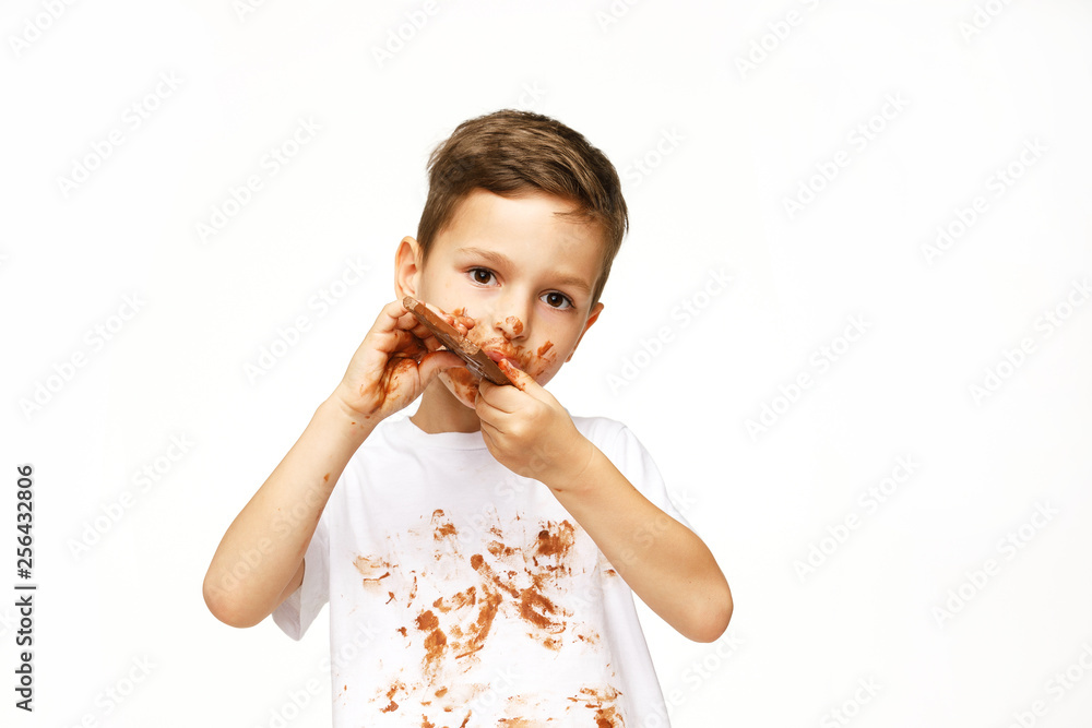 little messy boy is eating chocolate studio shot little messy boy is eating chocolate studio shot