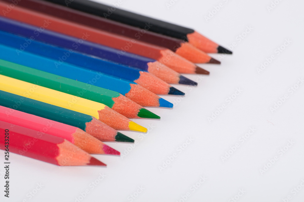 Color pencils on a white background close-up, macro, side view, with place for text. Color pencils on a white background close-up, macro, side view, with place for text.