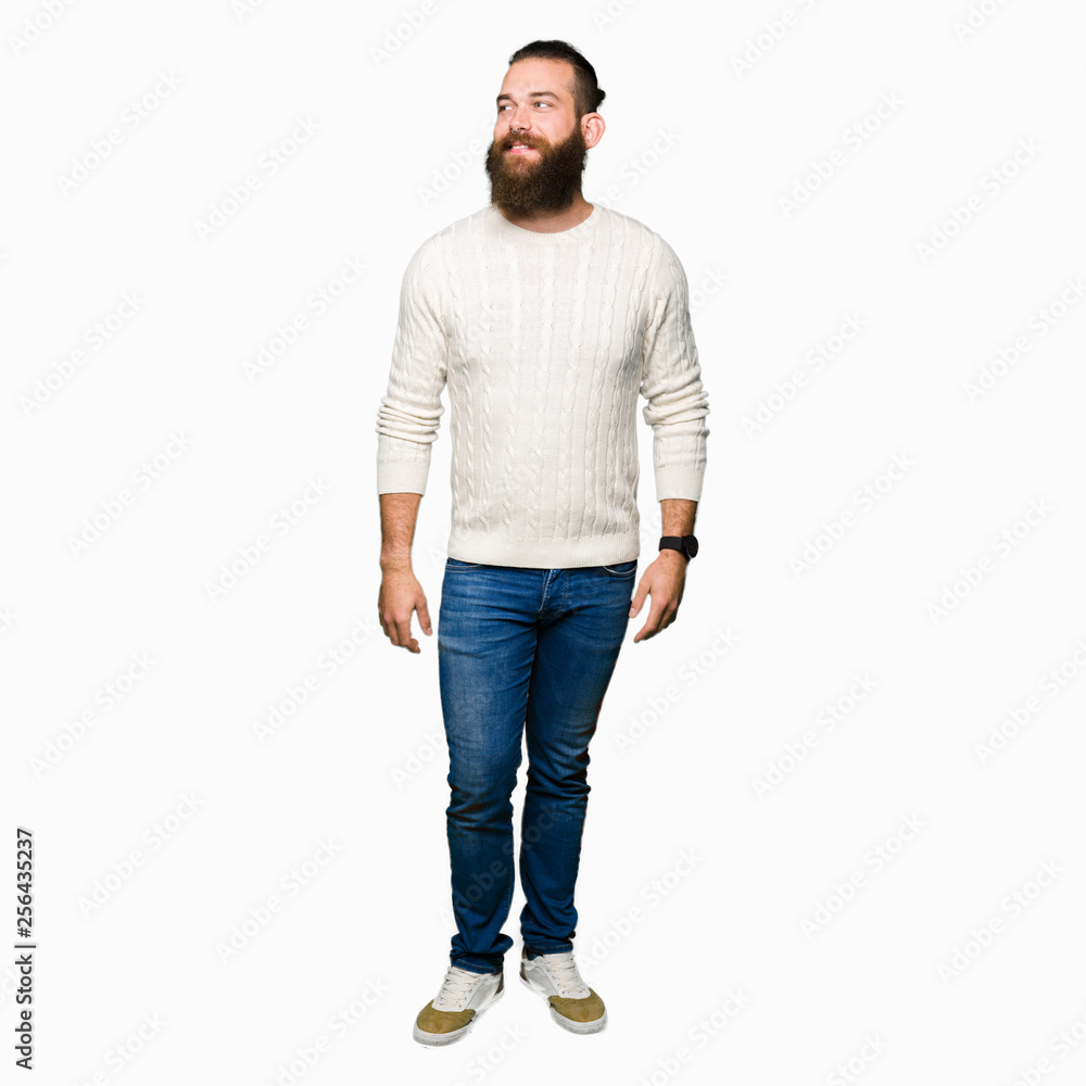 Young hipster man wearing winter sweater smiling looking side and staring away thinking. Young hipster man wearing winter sweater smiling looking side and staring away thinking.