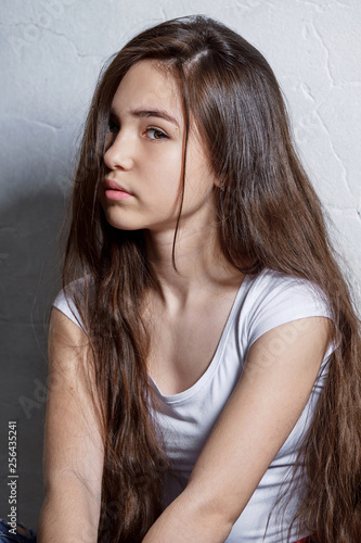 Closeup face teenager girl. Girl brunette asian. Vertical portrait fashion. Perfect young child model interracial appearance, looks confident, defiant