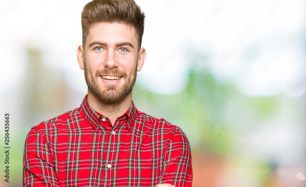 Fototapeta premium Young handsome man happy face smiling with crossed arms looking at the camera. Positive person.