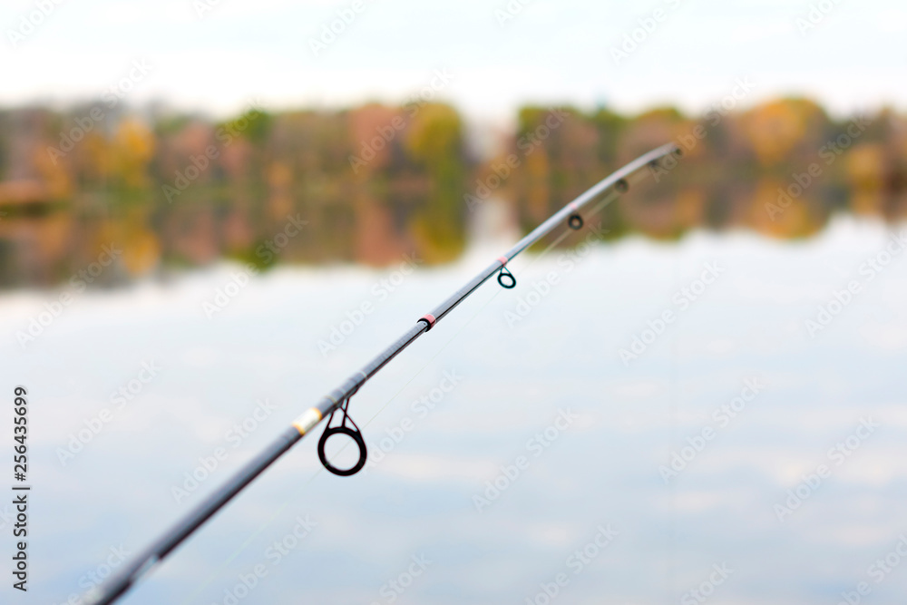 Fishing rod, spinning reel on the background pier river bank Fishing rod, spinning reel on the background pier river bank