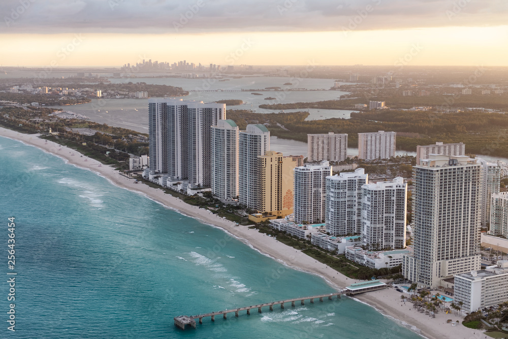 Miami Beach coastline at dusk. Amazing sunset view from helicopter. Skyscrapers and buildings