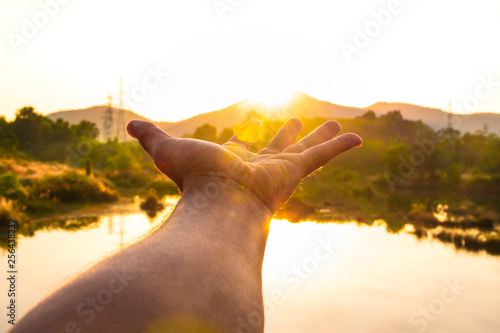 Use hand to touch the sun light in the morning, Pick up the sun, Close the sun in your hand, Yellow light with cold air in winter, Flare from sunrise, Symbols of hope