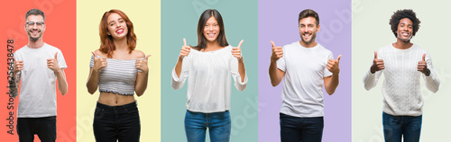 Composition of african american, hispanic and chinese group of people over vintage color background success sign doing positive gesture with hand, thumbs up smiling and happy. Looking at the camera