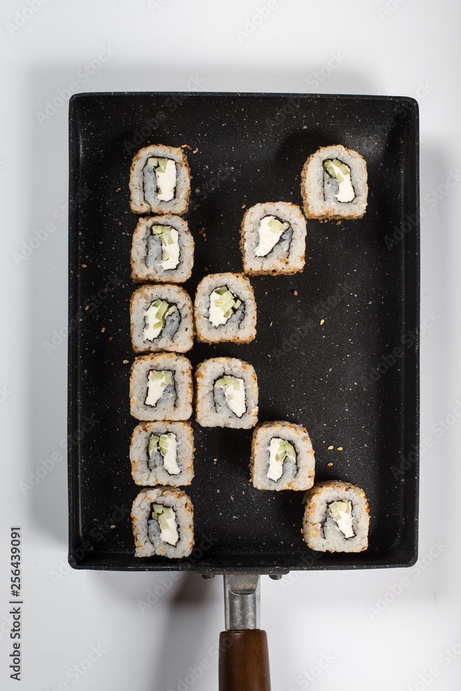 Japanese sushi rolls on a black plate in a forn of letter K. close view Japanese sushi rolls on a black plate in a forn of letter K. close view