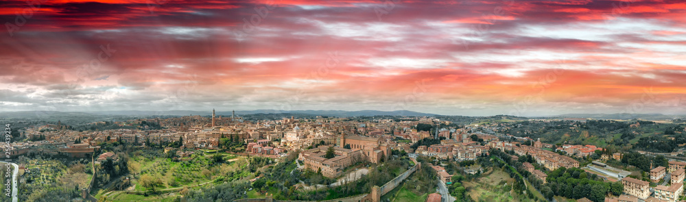 Amazing panoramic aerial view of Siena medieval skyline at sunset, Tuscany.