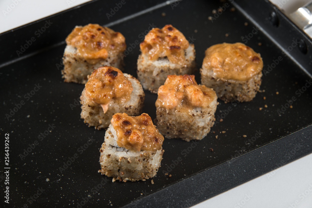 Japanese sushi rolls on a black frying pan. close view Japanese sushi rolls on a black frying pan. close view