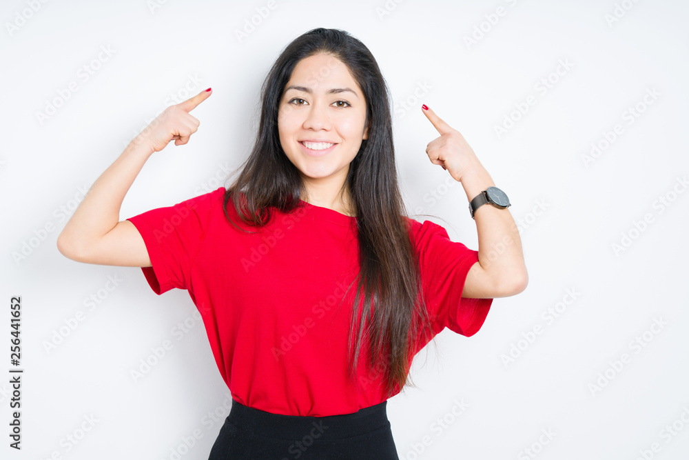 Beautiful brunette woman wearing red t-shirt over isolated background Smiling pointing to head with both hands finger, great idea or thought, good memory Beautiful brunette woman wearing red t-shirt over isolated background Smiling pointing to head with both hands finger, great idea or thought, good memory