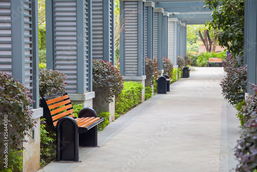 Empty outdoors promenade with resting chairs and bush in a new park,China photo