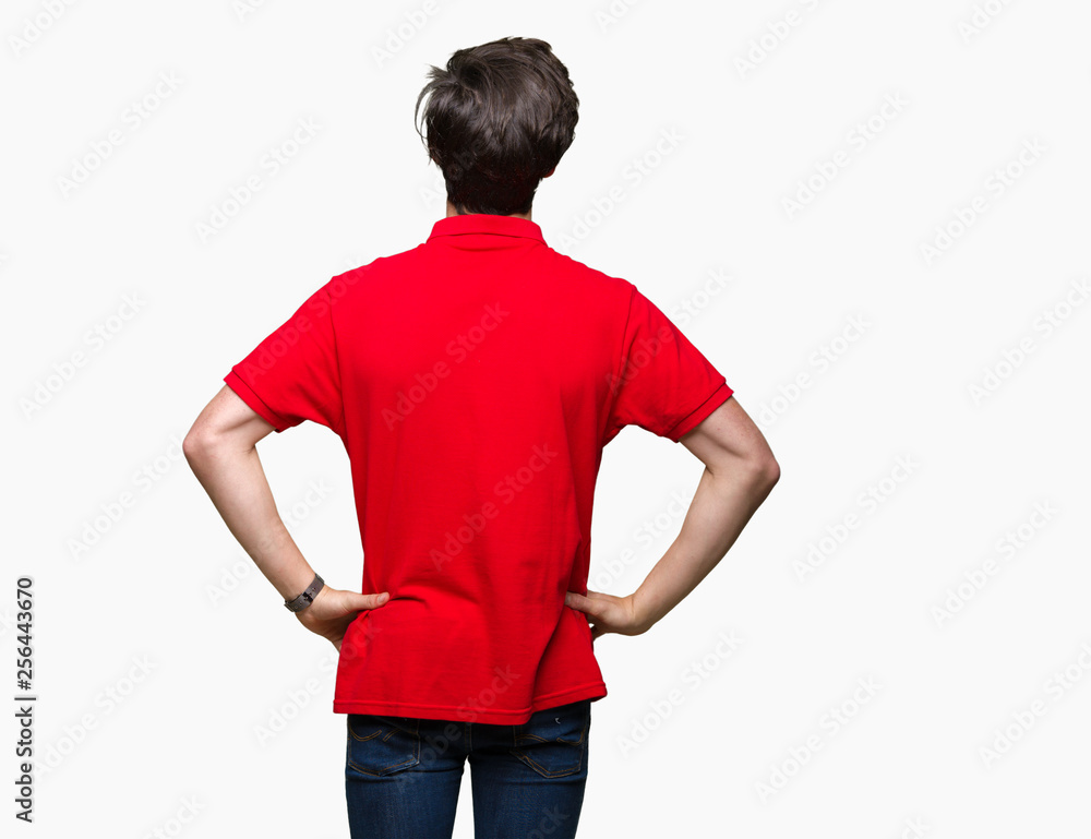 Young handsome man wearing red t-shirt over isolated background standing backwards looking away with arms on body Young handsome man wearing red t-shirt over isolated background standing backwards looking away with arms on body