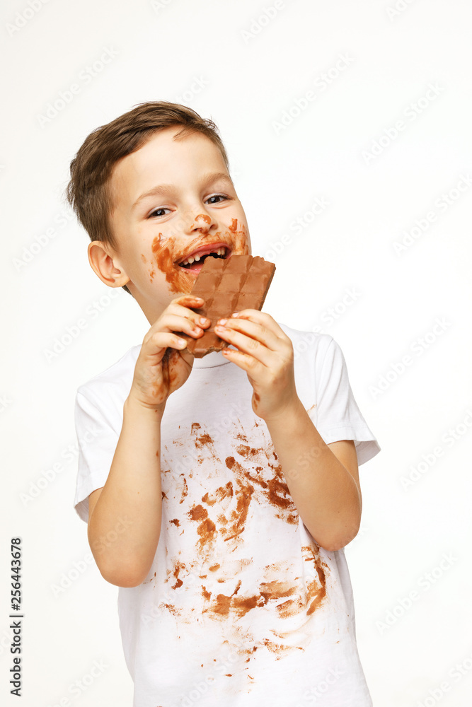 little messy boy is eating chocolate studio shot little messy boy is eating chocolate studio shot