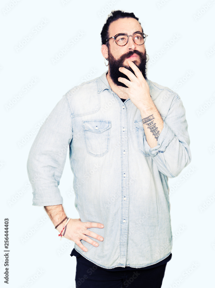Young hipster man with long hair and beard wearing glasses with hand on  chin thinking about question, pensive expression. Smiling with thoughtful  face. Doubt concept. Stock Photo | Adobe Stock