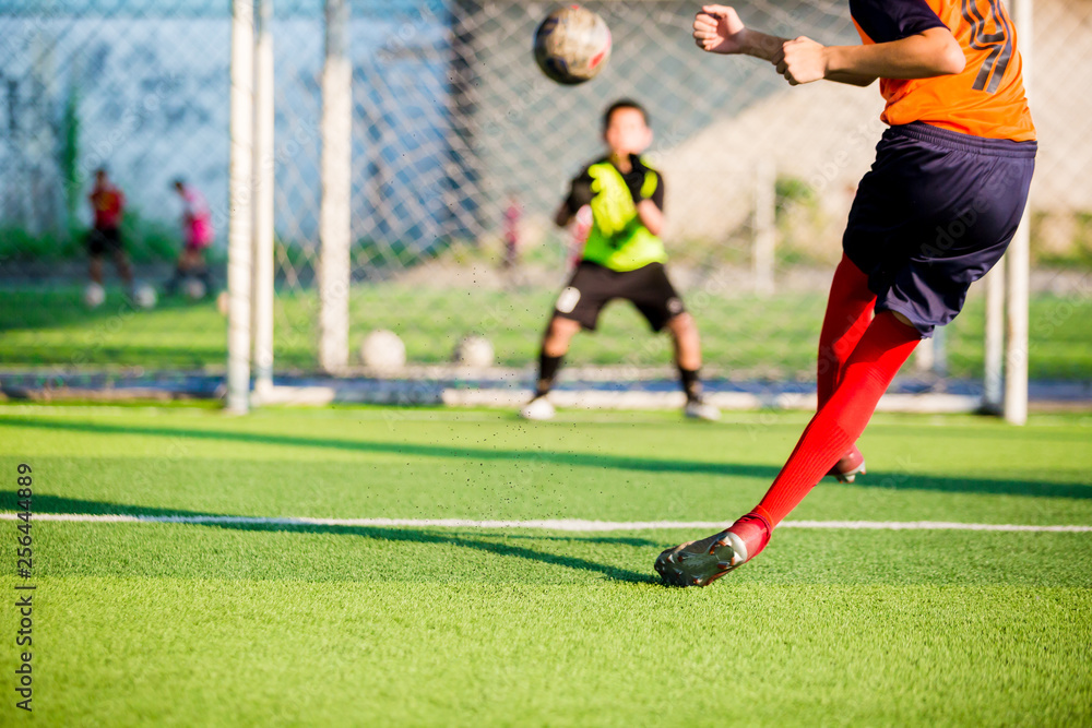 soccer player run to shoot ball at penalty kick to goal with blurry goalkeeper background, concept of making goals and protection soccer player run to shoot ball at penalty kick to goal with blurry goalkeeper background, concept of making goals and protection