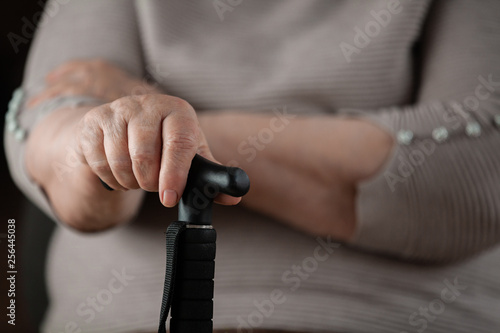  Female elderly hands hold a care wand. Retired woman.