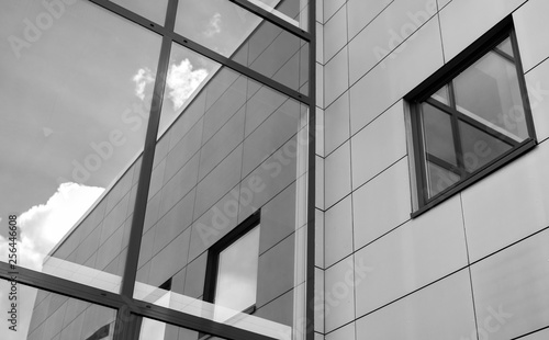black and white picture of modern trade building with reflection in window and blue sky