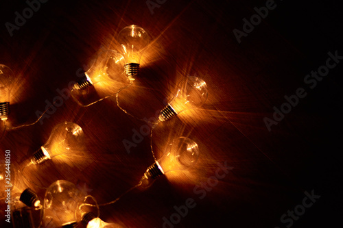 Garland of vintage bulb lamps with modern yellow LED lighting elements, close up photo