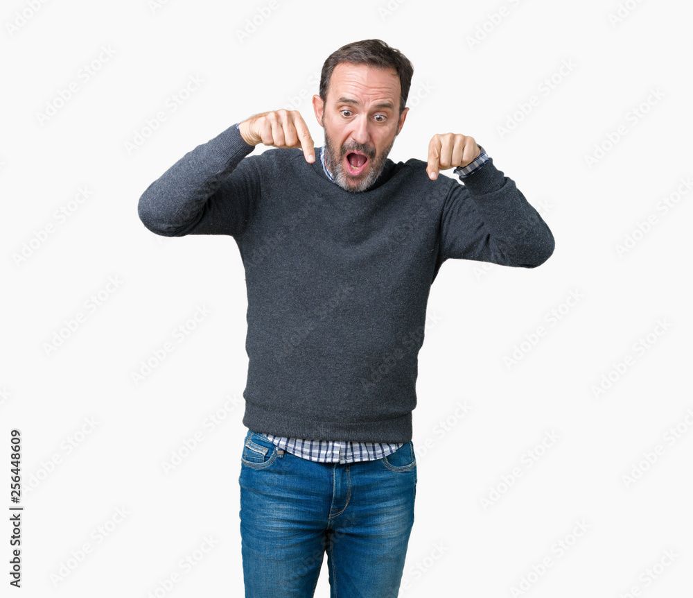 Handsome middle age senior man wearing a sweater over isolated background Pointing down with fingers showing advertisement, surprised face and open mouth Handsome middle age senior man wearing a sweater over isolated background Pointing down with fingers showing advertisement, surprised face and open mouth