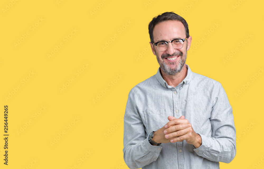 Handsome middle age elegant senior man wearing glasses over isolated background Hands together and fingers crossed smiling relaxed and cheerful. Success and optimistic