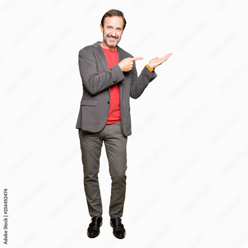 Middle age handsome business man amazed and smiling to the camera while presenting with hand and pointing with finger. Middle age handsome business man amazed and smiling to the camera while presenting with hand and pointing with finger.
