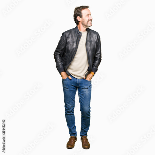 Middle age handsome man wearing black leather jacket looking away to side with smile on face, natural expression. Laughing confident.