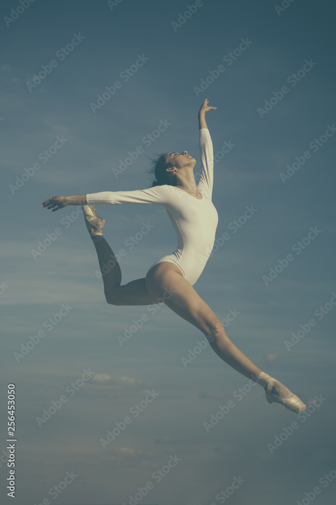 Fototapeta premium Grace in every move. Practicing art of classical ballet. Ballerina jumping on blue sky. Cute ballet dancer. Pretty woman in dance wear. Ballet class. Classic dance style. Concert performance dance