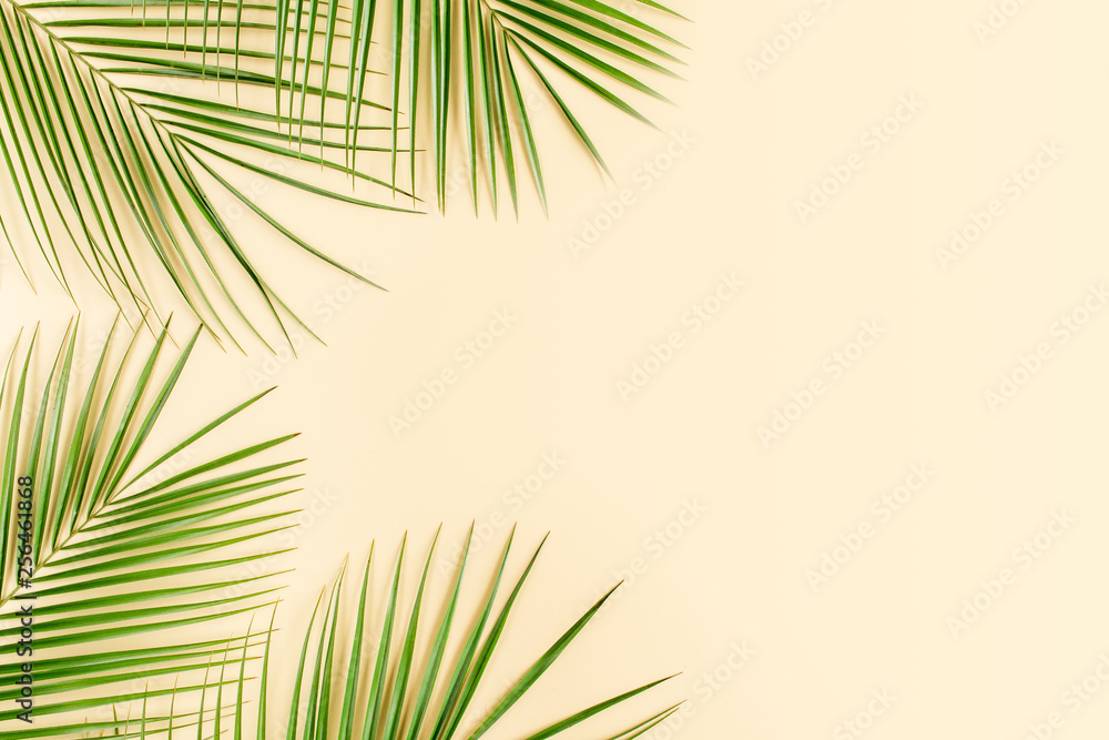 Tropical green palm leaves on yellow background. Flat lay, top view Tropical green palm leaves on yellow background. Flat lay, top view