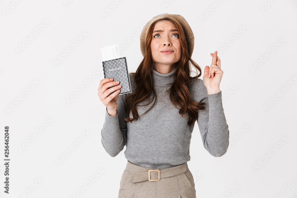 Emotional beautiful woman holding passport with tickets isolated over white wall background. Emotional beautiful woman holding passport with tickets isolated over white wall background.