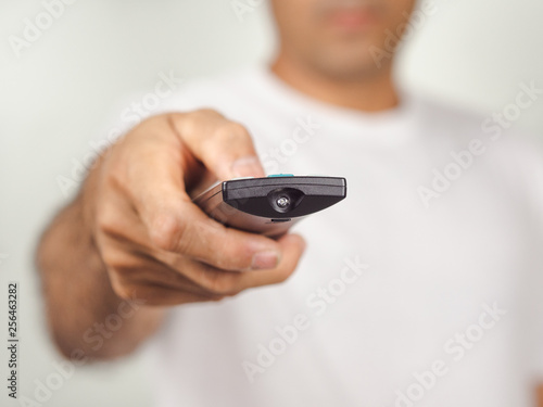 Closeup of a man pess the remote controller button on white background photo