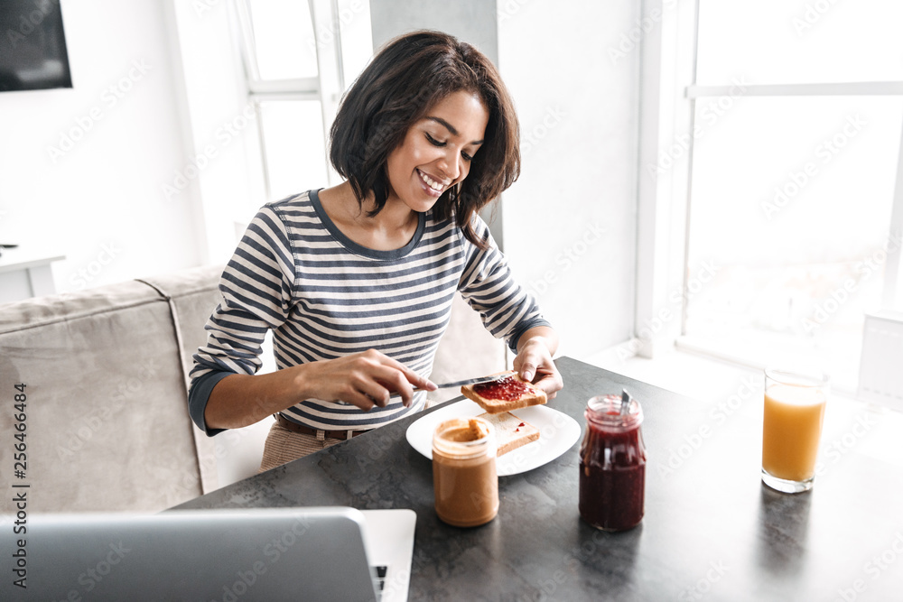 Smiling young african woman having breakfast Smiling young african woman having breakfast